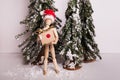 Jointed mannequin doll holding holiday Christmas present on winter scene