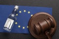 Wooden judge gavel and bottle of alcohol, EU flag background. Alcohol lawsuit in European Union concept Royalty Free Stock Photo