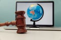 Wooden judge gavel close-up and globe on laptop. International law concept Royalty Free Stock Photo