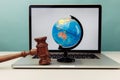 Wooden judge gavel and globe on laptop. International law concept Royalty Free Stock Photo