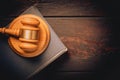 Wooden judge gavel hammer on a book and wooden table background. Dramatic light. Copy space Royalty Free Stock Photo