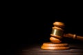 Wooden judge gavel hammer on wooden table against black background. Dramatic light. Copy space Royalty Free Stock Photo