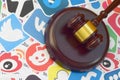 Wooden judge gavel lies on many paper logos of popular social networks and internet resources. Entertainment lawsuit concept