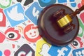 Wooden judge gavel lies on many paper logos of popular social networks and internet resources. Entertainment lawsuit concept