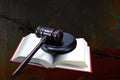 Wooden judge gavel and red book on barbed wire background as symbol of of rule of law with judge`s gavel, justice with judge`s ga