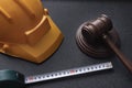 Wooden judge gavel, yellow building helmet and tape. Construction law concept. labor-related legal concept Royalty Free Stock Photo