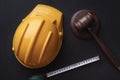 Wooden judge gavel, yellow building helmet and tape. Labor-related legal concept. Top view Royalty Free Stock Photo