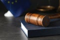 Wooden judge`s gavel and book on table against European Union flag, closeup. Space for text Royalty Free Stock Photo