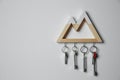 Wooden key holder on grey wall. Space for text Royalty Free Stock Photo
