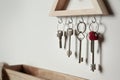 Wooden key holder on light wall. Space for text Royalty Free Stock Photo