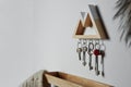 Wooden key holder on light wall. Space for text Royalty Free Stock Photo
