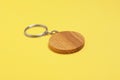 Wooden keychain in shape of smiley face on yellow background Royalty Free Stock Photo