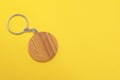 Wooden keychain in shape of smiley face on yellow background, top view. Space for text Royalty Free Stock Photo