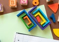 Wooden kids toys on colourful paper. Educational toys, blocks, pyramid, pencils, numbers, rainbow. Toys for kindergarten, Royalty Free Stock Photo