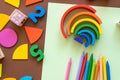 Wooden kids toys on colourful paper. Educational toys, blocks, pyramid, pencils, numbers, rainbow. Toys for kindergarten Royalty Free Stock Photo