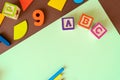 Wooden kids toys on colourful paper. Educational toys, blocks, pyramid, pencils, numbers, rainbow. Toys for kindergarten Royalty Free Stock Photo