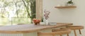 A wooden kitchen countertop with wooden armchairs in a beautiful Scandinavian kitchen