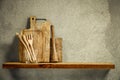 Wooden tray, kitchen tools on wooden shelf. Copy empty space for your decoration and products. Beige brown retro wall background. Royalty Free Stock Photo