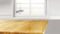 Wooden kitchen tabletop and window with blurred window  background. Royalty Free Stock Photo