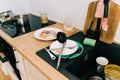 Wooden kitchen tabletop with black sink and dirty messy dish