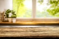 Wooden kitchen tabletop and window with blurred outside garden background. Royalty Free Stock Photo