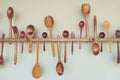Wooden kitchen tools: wooden spoon, wooden fork, wooden spatula, hang on white wall Royalty Free Stock Photo