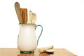 Wooden kitchen utensils in a ceramic jar against a white background. Royalty Free Stock Photo