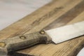 Wooden knife on grainy old fashioned cutting board