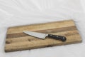Wooden knife on grainy old fashioned cutting board