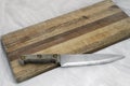 Wooden knife on grainy old fashioned cutting board