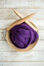 Wooden knitting needles and purple merino wool ball in a basket Royalty Free Stock Photo