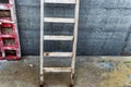 Wooden ladder at the construction site against the background of a concrete wall. Work at height. Security engineering Royalty Free Stock Photo