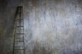 Wooden ladder leaning against textured wall. The concept of the career ladder