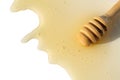 A wooden ladle with honey lies on a white isolated background.