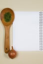 Wooden ladle with spices, eggs and garlic with a blank notebook page Royalty Free Stock Photo
