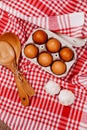 Wooden ladles and eggs on a red and white table rug