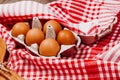 Wooden ladles and eggs on a red and white table rug