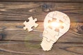 Wooden lamp from puzzles on a wooden background.