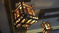 Wooden lantern swaying on a ceiling, interior light. Warm yel