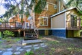 Wooden large American house with natural brown tone with white trim and green summer nature