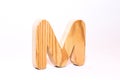 Wooden letter m carved from wood with a beautiful wood texture on a white background Royalty Free Stock Photo