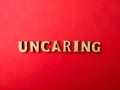 Wooden letters arranged into the word UNCARING Royalty Free Stock Photo