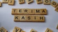 Wooden letters arranged into the word "terima kasih" or thank you on a white background