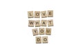 Wooden letters with black capital letters with the phrase `Love what you do` on white background