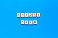 Wooden letters credit card on a blue background. banner, free metos, space for text, top view, flat layout