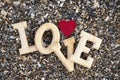 Wooden letters forming the word love with a red heart on a background of beach sand. concept of san valentine Royalty Free Stock Photo
