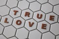 Letters forming the words True Love on hexagon shaped tiles