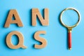 Wooden letters and magnifier glass on blue background, flat lay. Find keywords concept