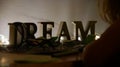 Wooden letters spelling out DREAM on an illuminated table