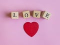 wooden letters with word love and red heart on white-pink background. Wooden letter blocks. Loving, positive emotions. Valentines Royalty Free Stock Photo